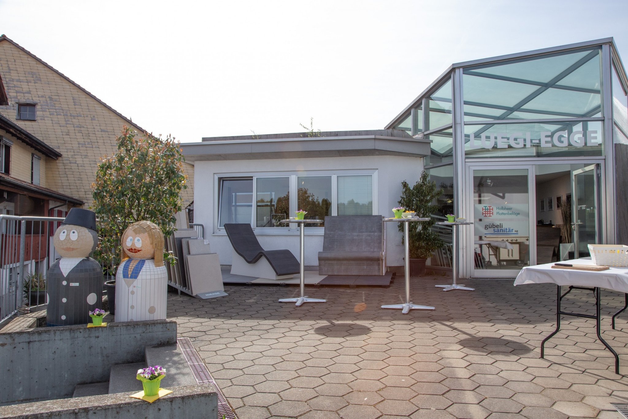 Ausstellung Luegi Egge von aussen mit Mosaikfiguren auf der Terrasse