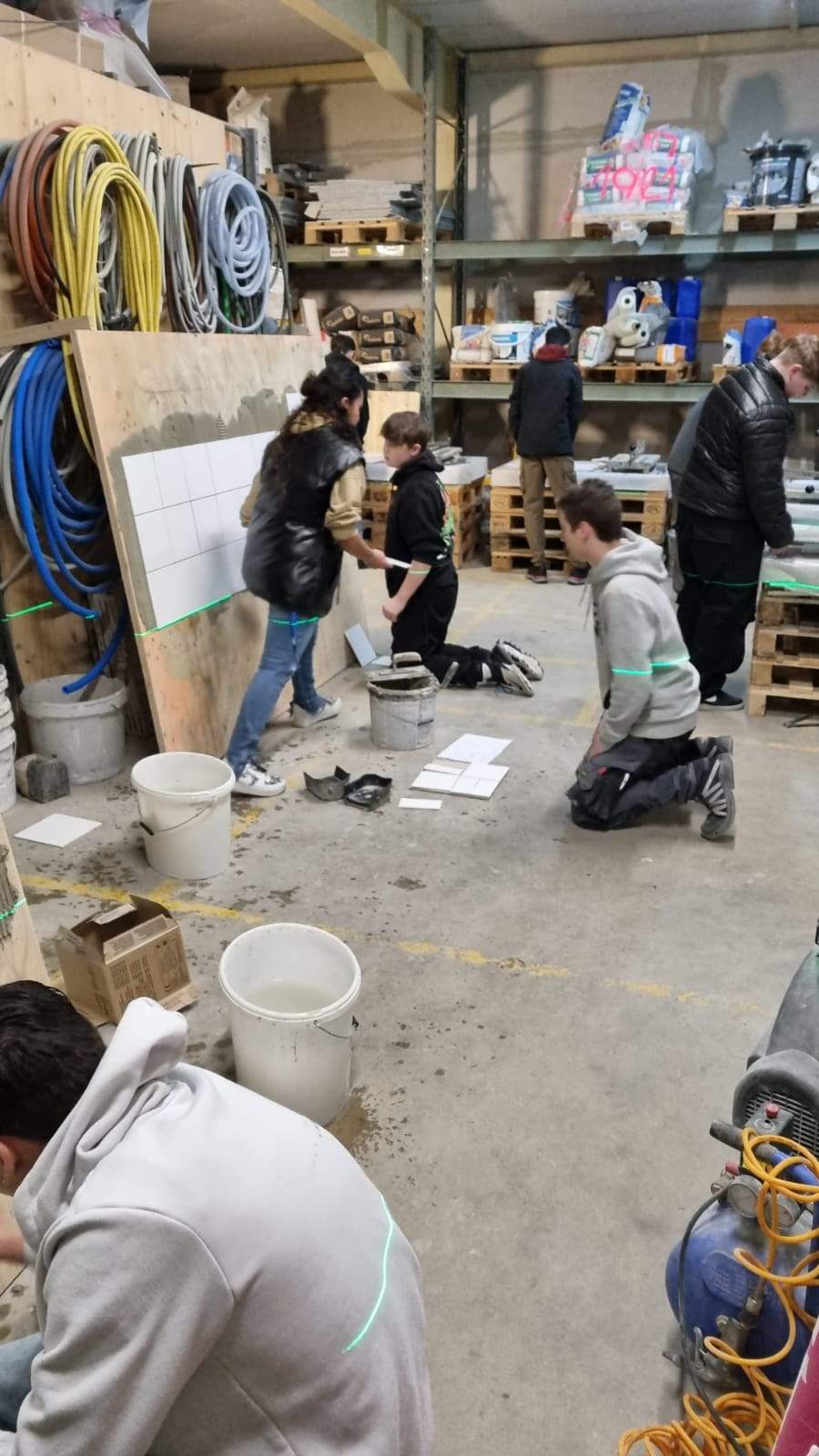 Schülerinnen und Schüler beim Plattenlegen in der Werkstatt